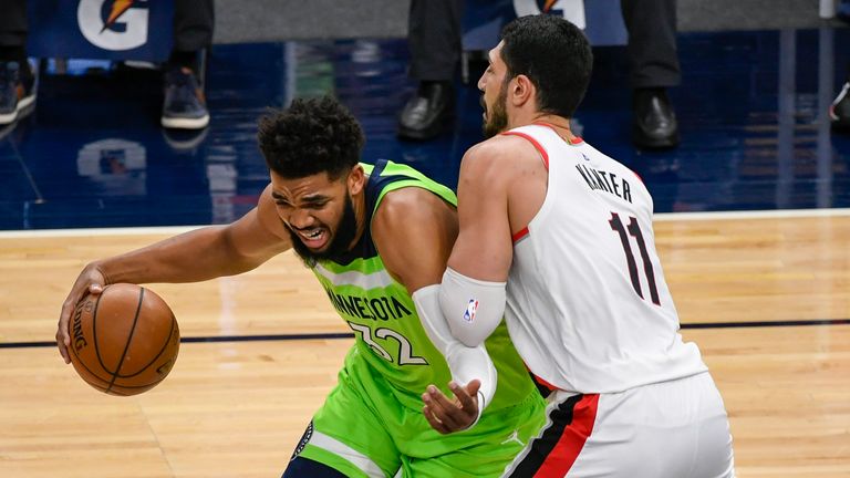 Minnesota Timberwolves center Karl-Anthony Towns (32) drives past Portland Trail Blazers center Enes Kanter (11) during the first half of an NBA basketball game Saturday, March 13, 2021, in Minneapolis.