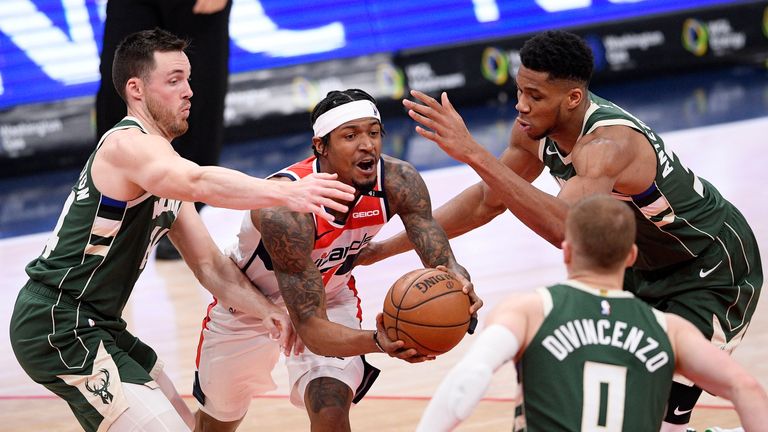 Washington Wizards guard Bradley Beal, center, goes to the basket against Milwaukee Bucks forward Giannis Antetokounmpo, right, guard Pat Connaughton, left, and guard Donte DiVincenzo (0) during the second half of an NBA basketball game, Monday, March 15, 2021, in Washington.