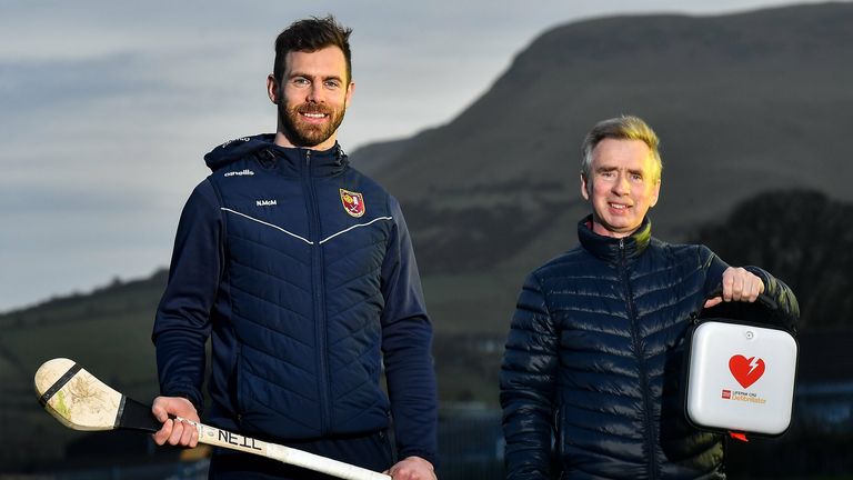 Antrim hurler Neil McManus and his father Hugh at Cushendall GAA Club in Antrim. The GAA Community Heart Programme seeks to raise awareness of the benefits of defibrillators to clubs and make it possible to fundraise to acquire them. Neil's work is inspired by his family experience five years ago when his father was saved by the presence of a defibrillator in the community during an emergency. GAA club-based defibrillators have been used to save 42 lives