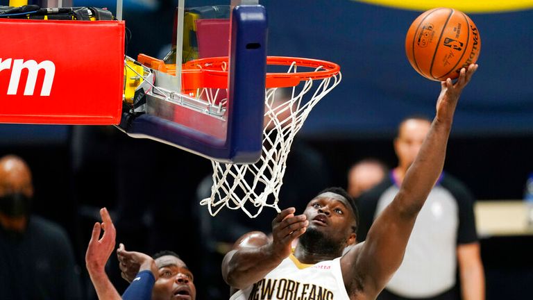 AP- New Orleans Pelicans forward Zion Williamson, right, drives to the rim as Denver Nuggets center Nikola Jokic defends