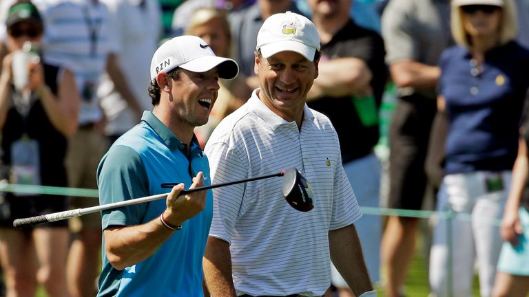 Rory McIlroy, of Northern Ireland, walks with Jeff Knox, right, down the eighth fairway during the third round of the Masters
