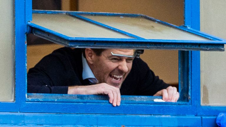 Steven Gerrard celebrates out the dressing room window with fans outside Ibrox after Rangers moved to within reach of the title with victory over St Mirren