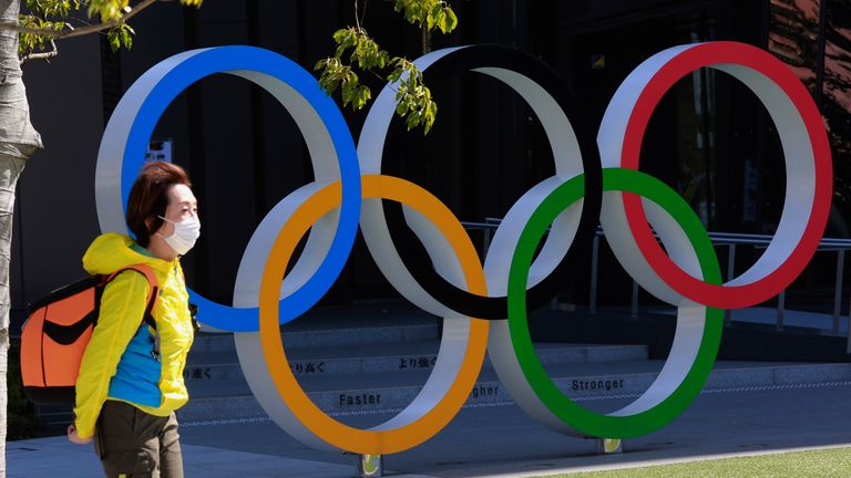 AP - A woman walks past the Olympic rings in Tokyo, Wednesday, March 10, 2021. (AP Photo/Koji Sasahara)