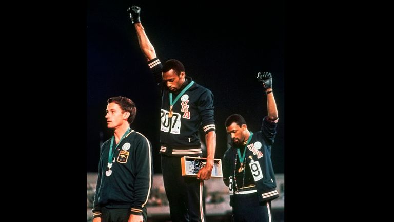 Extending gloved hands skyward in racial protest, U.S. athletes Tommie Smith, center, and John Carlos stare downward during the playing of the Star Spangled Banner after Smith received the gold and Carlos the bronze for the 200 meter run at the Summer Olympic Games in Mexico City on Oct. 16, 1968. Australian silver medalist Peter Norman is at left. (AP Photo)