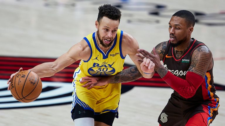 Golden State Warriors guard Stephen Curry dribbles past Portland Trail Blazers guard Damian Lillard