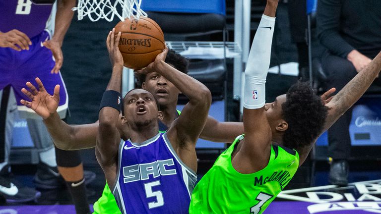 Sacramento Kings guard De&#39;Aaron Fox (5) shoots as Minnesota Timberwolves forward Jaden McDaniels (3) defends during the second half of an NBA basketball game in Sacramento, Calif., Tuesday, April 20, 2021. The Timberwolves won 134-120.