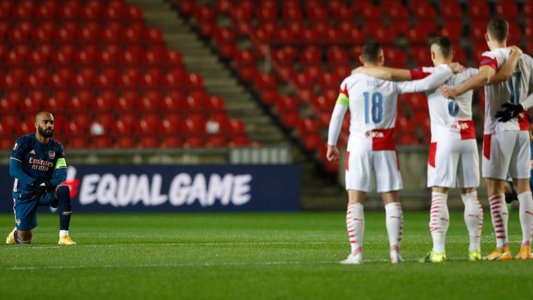 Arsenal's Alexandre Lacazette, left, takes a knee in support of Black Lives Matter movement prior the Europa League quarter final second leg soccer match between Slavia Prague and Arsenal at the Sinobo stadium in Prague, Czech Republic, Thursday, April 15, 2021. (AP Photo/Petr David Josek)