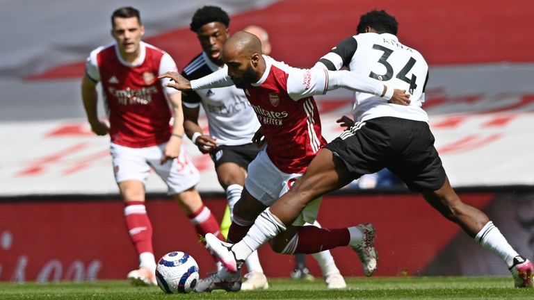 Arsenal's Alexandre Lacazette, centre, tries to get past Fulham's Ola Aina, right, during an English Premier League soccer match between Arsenal and Fulham at the Emirates stadium