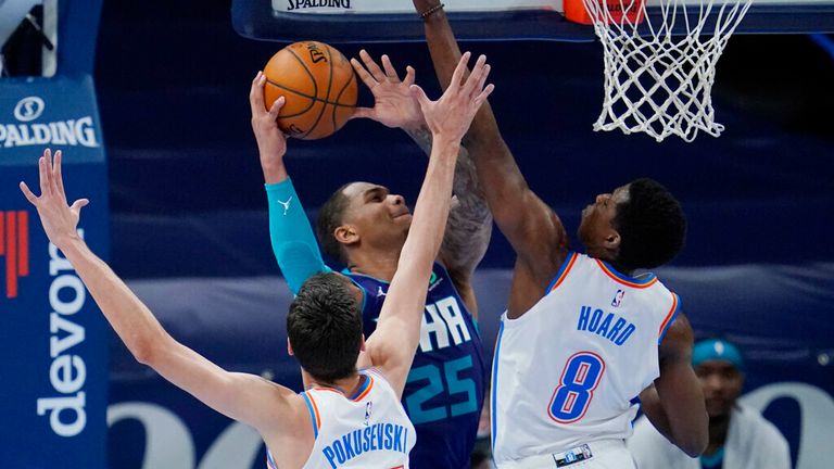 AP - Charlotte Hornets forward P.J. Washington (25) goes to the basket defended by Oklahoma City Thunder forward Aleksej Pokusevski