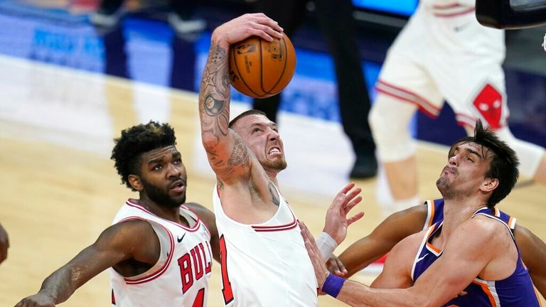 AP - Chicago Bulls center Daniel Theis, middle, pulls down a rebound as Phoenix Suns forward Dario Saric, right, and Bulls forward Patrick Williams