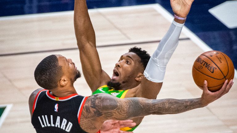 Portland Trail Blazers guard Damian Lillard lays the ball up while guarded by Utah Jazz guard Donovan Mitchell