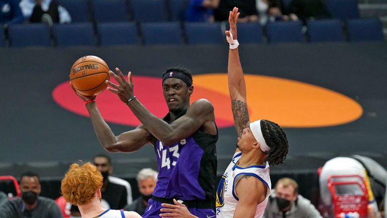 Toronto Raptors forward Pascal Siakam passes the ball between Golden State Warriors&#39; Nico Mannion and Damion Lee