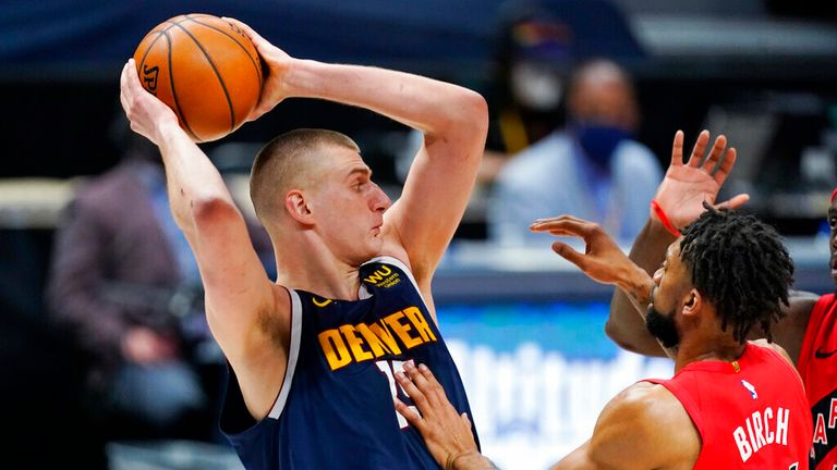 AP - Denver Nuggets center Nikola Jokic, left, pulls in a rebound as center Khem Birch defends