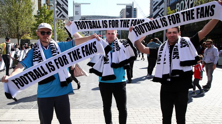 Supporters display their "Football is for the fans" scarves before kick-off at Wembley