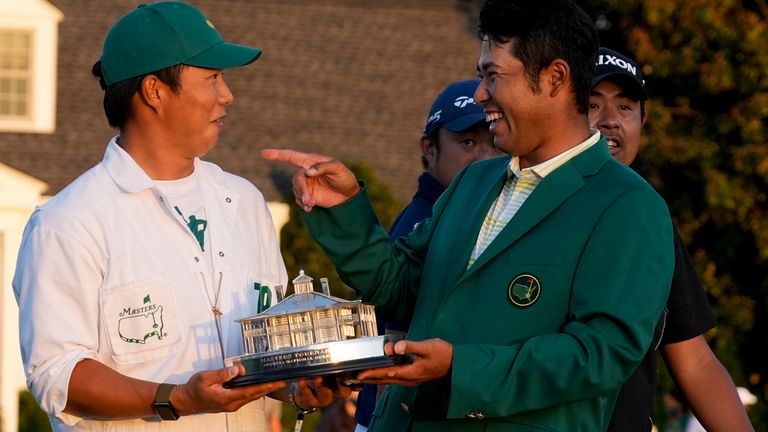 Hideki Matsuyama, of Japan, holds his trophy with his caddie Shota Hayafuji after winning the Masters golf tournament on Sunday, April 11, 2021, in Augusta, Ga.  (AP Photo/David J. Phillip)