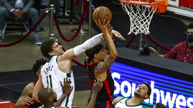 AP - Houston Rockets forward D.J. Wilson (00) shoots the ball as Milwaukee Bucks center Brook Lopez (11) defends