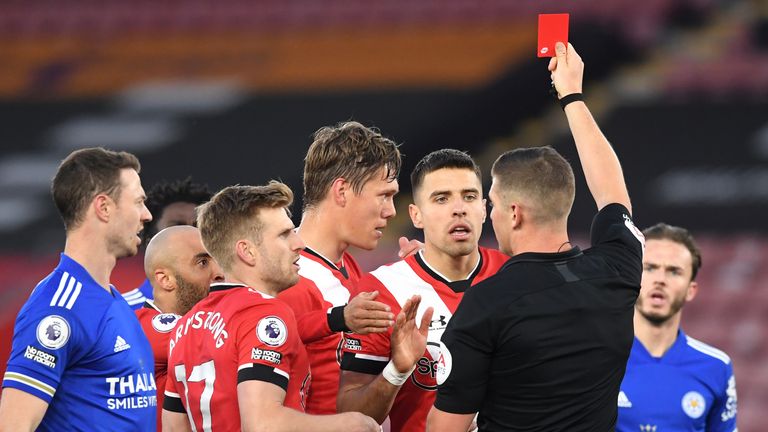 Referee Robert Jones shows a red card to Southampton's Jannik Vestergaard for his challenge on Leicester's Jamie Vardy