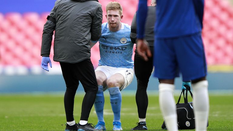 Kevin De Bruyne is helped to his feet after picking up a knock