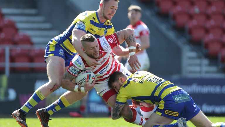 Leigh's Lewis Tierney is wrapped up by the Warrington defence