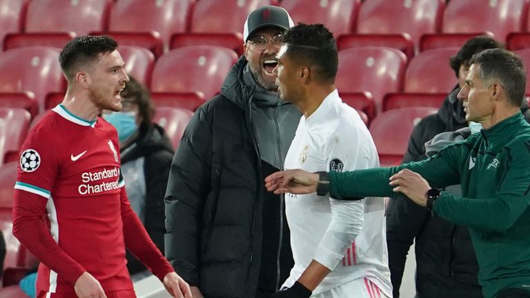 Liverpool's manager Jurgen Klopp, background, yells as Liverpool's Andrew Robertson, left, argues with Real Madrid's Casemiro