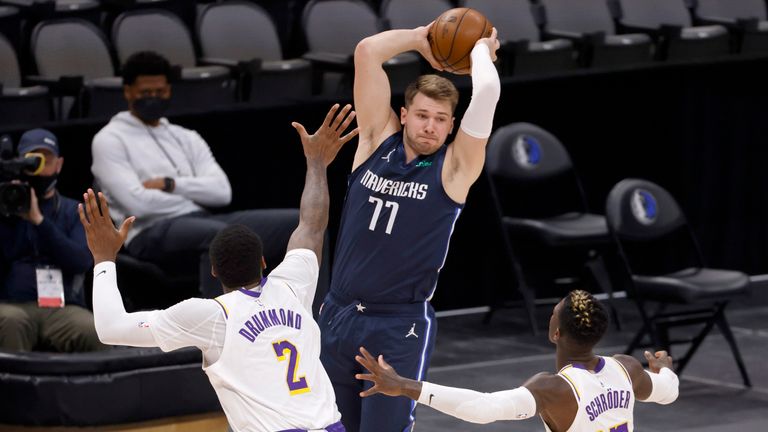 El escolta de los Dallas Mavericks, Luka Doncic (77), busca pasar al centro de Los Angeles Lakers, Andre Drummond (2), y al escolta Dennis Schroeder (17), durante la primera mitad de un partido de baloncesto de la NBA el sábado 24 de abril de 2021 en Dallas.  (Foto AP / Ron Jenkins)