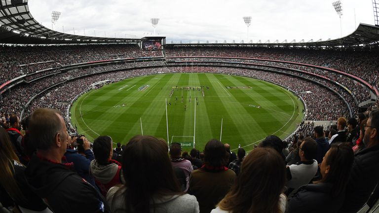 The crowd stand for the Last Post during the round six AFL match between the Collingwood Magpies and the Essendon Bombers at Melbourne Cricket Ground on April 25, 2021 in Melbourne, Australia.