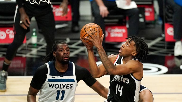 Los Angeles Clippers guard Terance Mann, right, shoots as Minnesota Timberwolves center Naz Reid defends during the first half of an NBA basketball game Sunday, April 18, 2021, in Los Angeles. (AP Photo/Mark J. Terrill) 