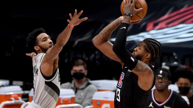 Los Angeles Clippers guard Paul George hits a shot over Portland Trail Blazers forward Derrick Jones Jr., left, during the second half of an NBA basketball game in Portland, Ore., Tuesday, April 20, 2021. The Clippers won 113-112. 