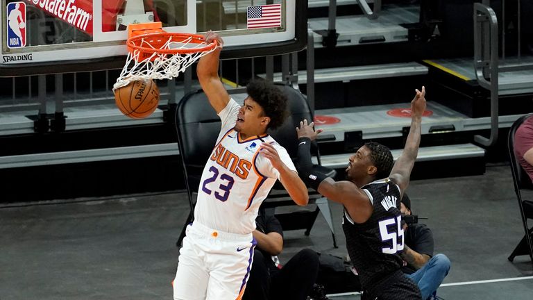 Phoenix Suns forward Cameron Johnson (23) dunks as Sacramento Kings guard Delon Wright (55) defends during the second half of an NBA basketball game, Thursday, April 15, 2021, in Phoenix.(AP Photo/Matt York)


