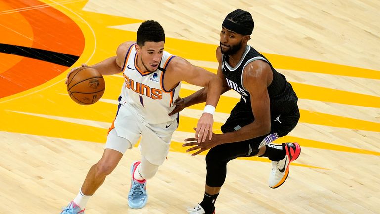 Phoenix Suns guard Devin Booker (1) drives as Sacramento Kings forward Maurice Harkless defends during the first half of an NBA basketball game, Thursday, April 15, 2021, in Phoenix.(AP Photo/Matt York)


