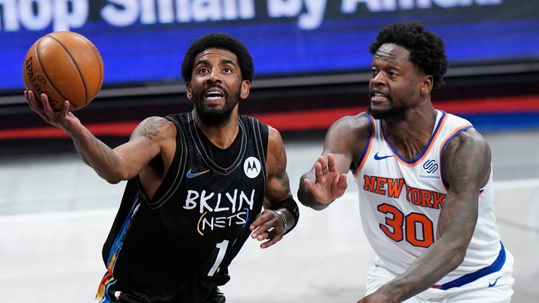 Brooklyn Nets&#39; Kyrie Irving (11) drives past New York Knicks&#39; Julius Randle (30) during the first half of an NBA basketball game Monday, April 5, 2021, in New York.