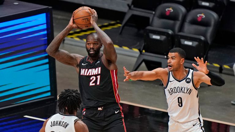 Miami Heat center Dewayne Dedmon (21) passes the ball past Brooklyn Nets forward Alize Johnson (24) and guard Timothe Luwawu-Cabarrot (9) during the first half of an NBA basketball game, Sunday, April 18, 2021, in Miami. (AP Photo/Wilfredo Lee) 