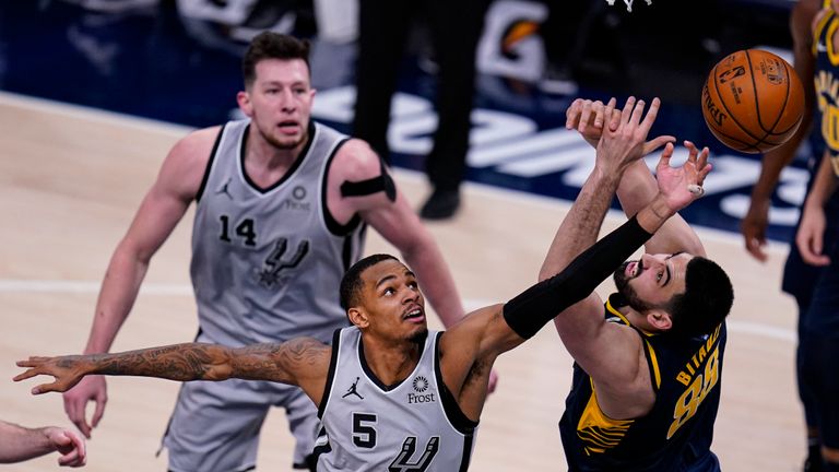 San Antonio Spurs guard Dejounte Murray (5) goes up for a rebound over Indiana Pacers center Goga Bitadze (88) during the second half of an NBA basketball game in Indianapolis, Monday, April 19, 2021. (AP Photo/Michael Conroy) 