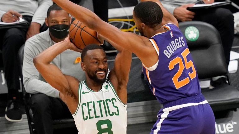 Boston Celtics guard Kemba Walker (8) passes the ball against the defense of Phoenix Suns forward Mikal Bridges (25) in the first half of an NBA basketball game, Thursday, April 22, 2021, in Boston.