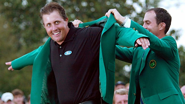 Phil Mickelson puts on his 2004 Master green jacket with the help of last year's winner Canada's Mike Weir at the Augusta National Golf Club in Augusta, Ga., Sunday, April 11, 2004