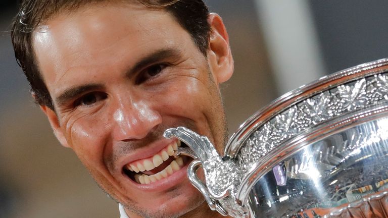 Spain's Rafael Nadal bites the trophy as he celebrates winning the final match of the French Open tennis tournament against Serbia's Novak Djokovic in three sets, 6-0, 6-2, 7-5, at the Roland Garros stadium in Paris, France, Sunday, Oct. 11, 2020. (AP Photo/Christophe Ena)