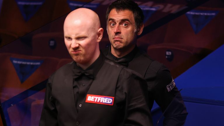 Ronnie O'Sullivan of England reacts behind Anthony McGill of Scotland during the Betfred World Snooker Championship Round Two match between Anthony McGill of Scotland and Ronnie O'Sullivan of England at Crucible Theatre on April 22, 2021 in Sheffield, England. A maximum of 50% of the venue capacity is allowed to open for spectators as part of a Government pilot event. (Photo by George Wood/Getty Images)