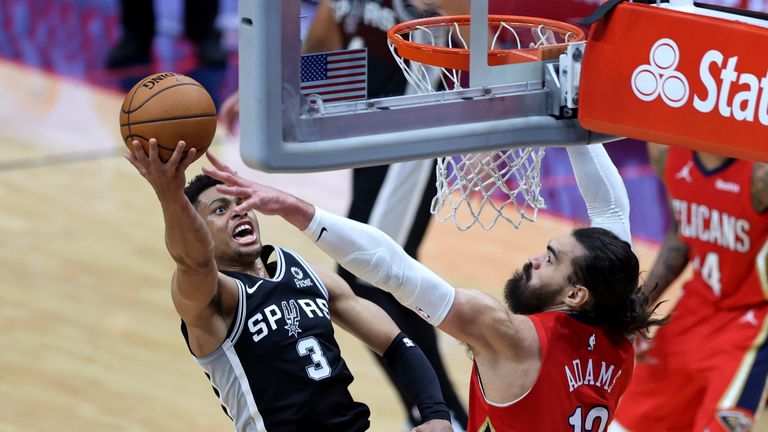 El alero de los San Antonio Spurs Keldon Johnson (3) dispara mientras el pívot de los New Orleans Pelicans, Steven Adams (12), defiende durante la segunda mitad de un juego de baloncesto de la NBA en Nueva Orleans, el sábado 24 de abril de 2021 (AP Photo / Rusty Costanza).