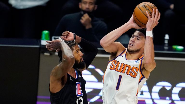 Phoenix Suns guard Devin Booker shoots over Los Angeles Clippers guard Paul George