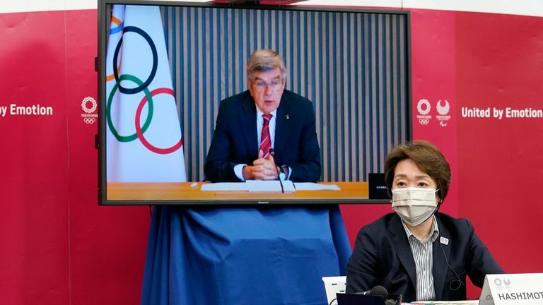 IOC president Thomas Bach (on a screen) delivers an opening speech while Tokyo 2020 Organizing Committee president Seiko Hashimoto watches on (AP)                