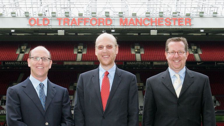 MANCHESTER, ENGLAND - JUNE 30:  Joel Glazer (left), Avram Glazer (centre) and Bryan Glazer (right), sons of new Manchester United owner Malcolm Glazer and new members of the board of directors pose at Old Trafford on June 30 2005 in Manchester, England. (Photo by Matthew Peters/Manchester United via Getty Images) *** Local Caption *** Joel Glazer;Avram Glazer;Bryan Glazer