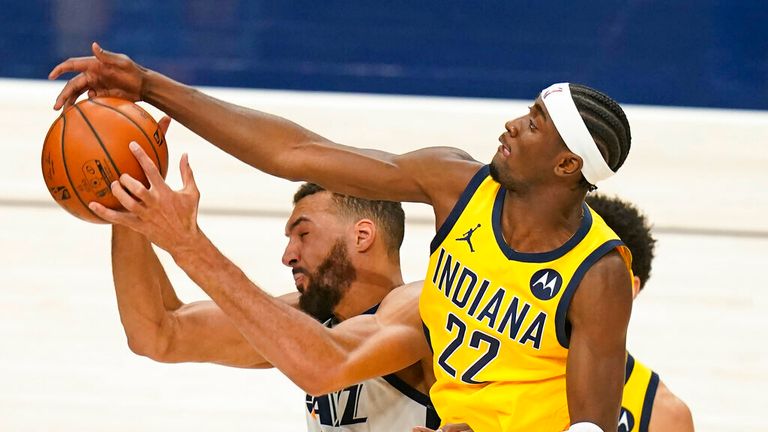 AP - Utah Jazz center Rudy Gobert, left, pulls down a rebound as Indiana Pacers guard Caris LeVert (22) defends