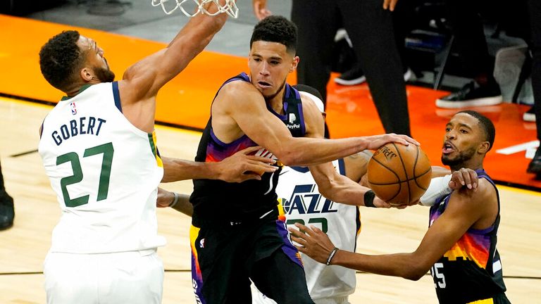 AP - Phoenix Suns guard Devin Booker, right, dishes off around Utah Jazz center Rudy Gobert (27)