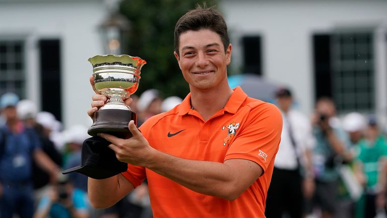 Viktor Hovland, of Norway, holds up his low amateur trophy after the Masters golf tournament, Sunday, April 14, 2019