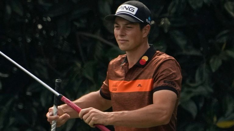 Viktor Hovland, of Norway, exchanges clubs with his caddie Shay Knight on the fifth hole during the first round of the Masters golf tournament on Thursday, April 8, 2021, in Augusta, Ga. (AP Photo/David J. Phillip)