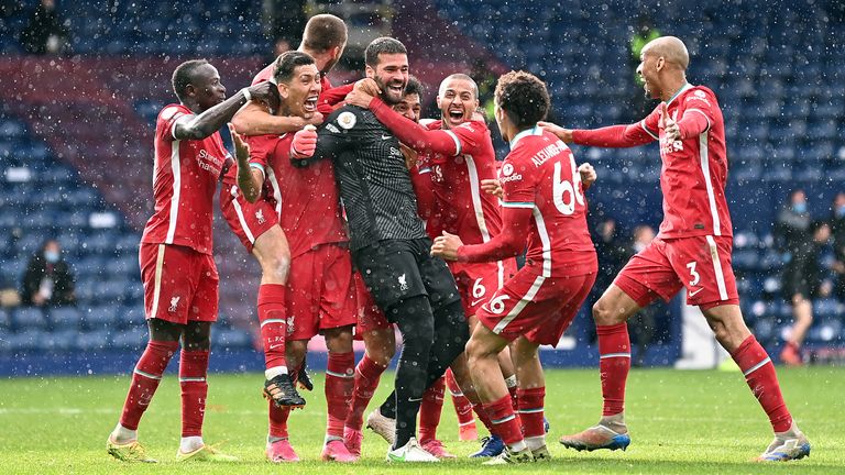 Alisson celebrates his late winner against West Brom with teammates