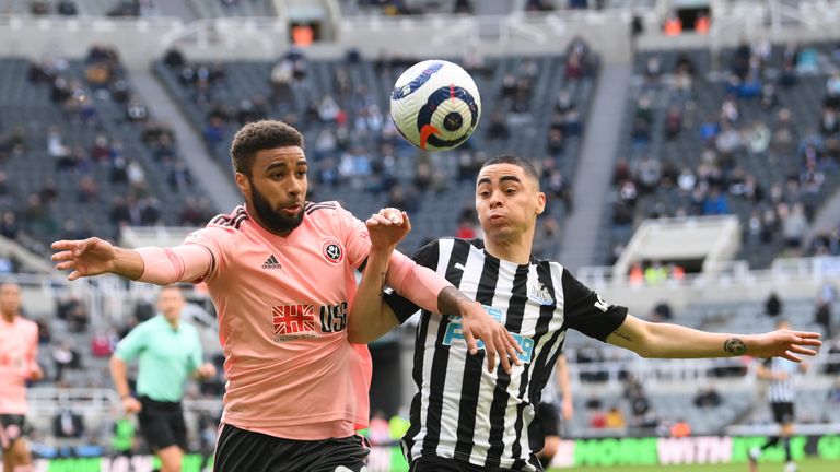 Sheffield United's Jayden Bogle and Newcastle's Miguel Almiron challenge for the ball during the English Premier League soccer match between Newcastle United and Sheffield United at St. James' Park in Newcastle, England, Wednesday, May 19, 2021. (Stu Forster/Pool via AP)