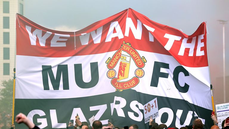 Los  fanáticos sostienen una pancarta mientras protestan contra la familia Glazer, propietarios del Manchester United, antes de su partido de la Premier League contra el Liverpool en Old Trafford, Manchester.  Fecha de emisión: domingo 2 de mayo de 2021.