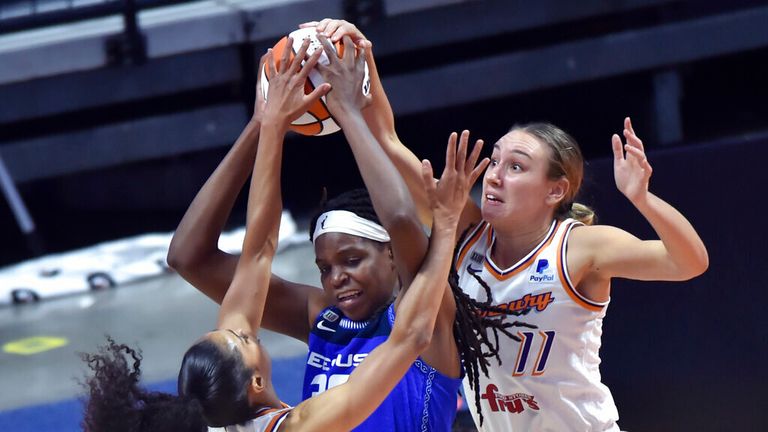 Connecticut Sun forward Jonquel Jones, center, is surrounded by Phoenix Mercury defenders Skylar Diggins-Smith, left, and Alanna Smith, right, in the home opener Sunday, May 16, 2021, in Uncasville, Conn. (Brad Horrigan/Hartford Courant via AP)