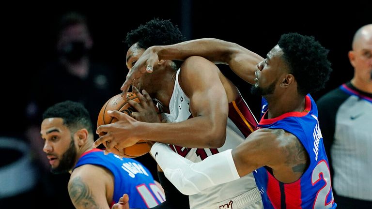 Detroit Pistons guard Josh Jackson (20) reaches in on Miami Heat forward KZ Okpala (11) during the second half of an NBA basketball game, Sunday, May 16, 2021, in Detroit. (AP Photo/Carlos Osorio)